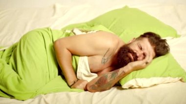 Adam sakallı hipster uyku ile ilgili sorunlar yaşıyor. Uyku. Adam çok derin bir uyku ile yatakta uyku. Yakışıklı adam uyku ve yumuşak yeşil yastık tutan fotoğraf.