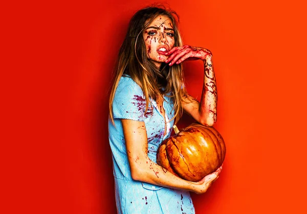 Halloween sexy studentka v krvi s dýní. Hororové Foto sexy dívka vrahů drží dýně v ruce. Žena, oblečená jako zombie na Halloween. Módní umění design. — Stock fotografie