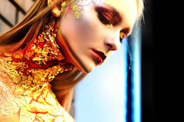 Tatil güzeli, parlak profesyonel makyajlı bir bayan. Altın makyaj. Altın Kadın. Kanlı dudaklı ve altın gözlü kadın.