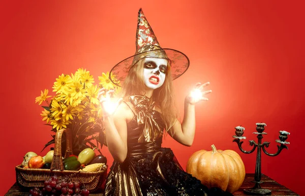 El niño en América celebra Halloween. Retrato de niña con disfraz de Halloween sobre fondo rojo . — Foto de Stock