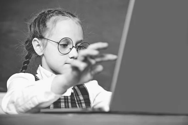 Kleine leerling leerling met laptop. Eerste keer naar school. Kleine leerling met Happy Face expressie in de buurt van Bureau met schoolbenodigdheden. Close-up. — Stockfoto