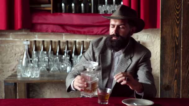 Homme vintage rétro avec whisky ou scotch. Tablier barman en cuir tenant cocktail whisky en verre. Boire de l'alcool. Hipster avec barbe et moustache en costume boit de l'alcool après la journée de travail . — Video