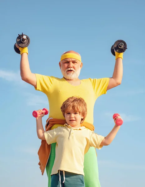 可爱的孩子和老年人练习哑铃。 健康的生活方式 父亲和孩子一起训练。 活跃的家庭喜欢运动和健身。 幼儿体育. — 图库照片