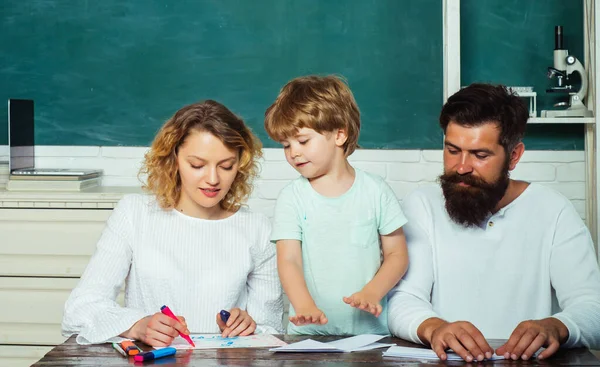 父母教育数学概念。 女人和男人帮助孩子。 幸福的年轻夫妇与他们的儿子一起站在毕业典礼上. 学习和教育概念. — 图库照片