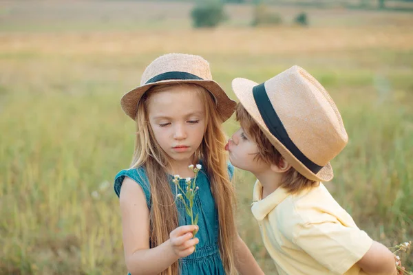 Sommerporträt glücklicher süßer Kinder. Kindheitserinnerungen. Romantik und Liebe. Liebe. Liebesgeschichte. Kindheitskonzept. glückliche Kinder Mädchen und Junge umarmen sich im Sommer auf der Wiese in der Natur. — Stockfoto