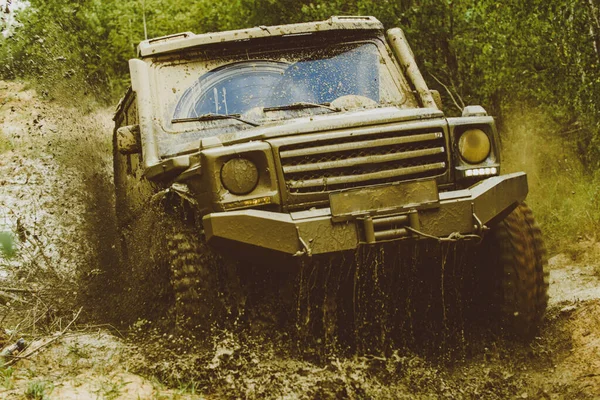 Plamy błota i wody w off-road wyścigach. Pojazd wychodzący z dziury w błocie. Przeciągnij samochód wyścigowy spala gumę. Ekstremalne. Samochód terenowy. Wyścigi rajdowe. — Zdjęcie stockowe