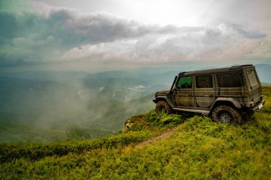 Çamurlu yolda su sıçratan klasik 4x4 araba. Off-road yarışında su sıçraması. Kamyon tekerleği off-road steppe macera patikasında.