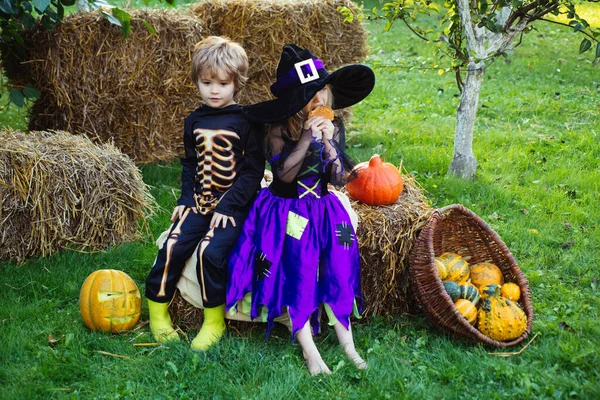 Gelukkige Halloween Leuke kinderen dochter en zoon die grappige gezichten trekken met een pompoen. Het concept van kindervriendschap, vrede, vriendelijkheid, kindertijd. — Stockfoto