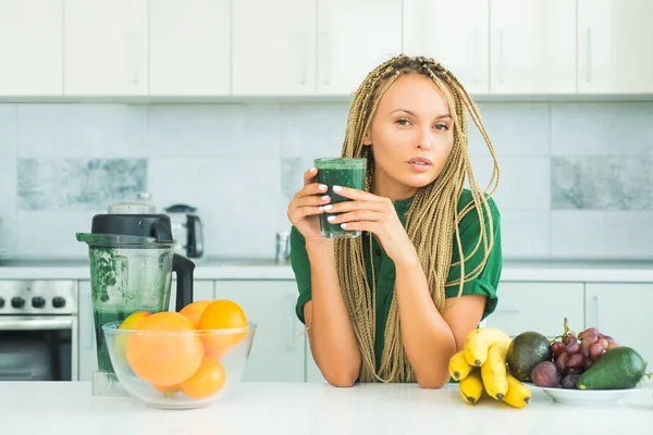 Making smoothie menu. Healthy eating alkaline diet. Healthy Green food. Weight loss. Healthy Lifestyle. Smiling young woman drinking green smoothie in kitchen.