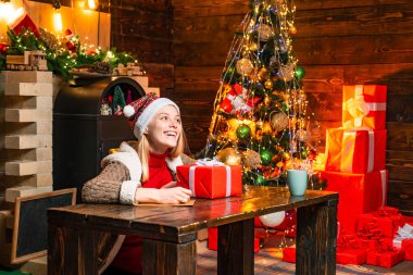 Mutluluk, neşe ve sevgi dolu. Kızlar sıcak bir Noel arifesinde sıcak atmosferin tadını çıkarırlar. Noel neşesi. Ahşap iç mekan Noel süsleri, çelenk ışıkları. Noel ağacı. Güzel anlar.