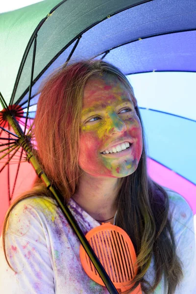 child with creative body art. colorful neon paint makeup. positive and cheerful. Crazy hipster girl. holi girl with umbrella. autumn weather. Happy youth party. Optimist. Spring vibes. Indian art
