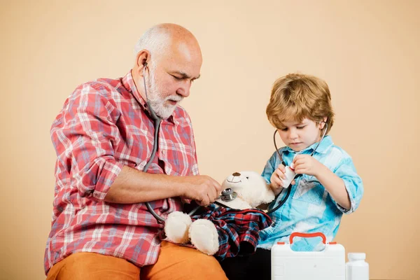 Patient recovery is going well. Child boy stroking the head of the sick grandfather. Elderly man and little kid doctor. Childhood.