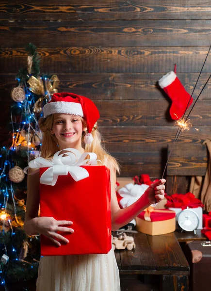 Roztomilá holčička zdobí vánoční stromeček uvnitř. Roztomilá holčička teenager zdobí vánoční stromeček uvnitř. Zimní večer doma. Novoroční děti. — Stock fotografie