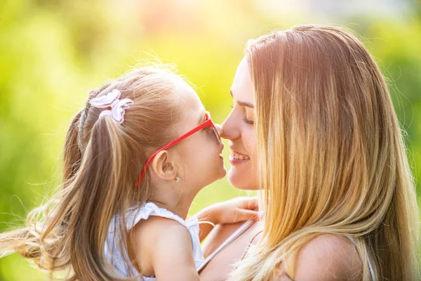 Family generation and people concept. Close-up portrait of smiling mother hugging cute little daughter. Little daughter hugging her happy mother.