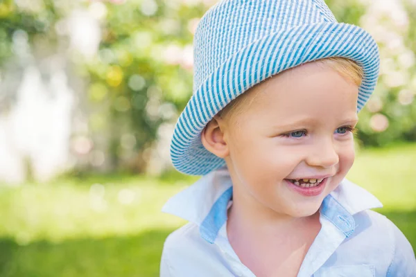 Kindergezicht. Portret van een vrolijk lachend kind op de achtergrond van de natuur. Kind buiten spelen. Grappig jongetje. — Stockfoto