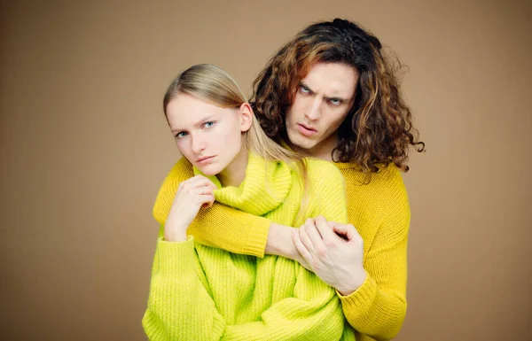 Insoddisfatto di abbracciare una giovane coppia. Conflitto familiare discordia di due concetti di genere. Abuso di autorità in famiglia. Giovane coppia avendo una discussione sullo sfondo di colore. Problemi di relazione . — Foto Stock