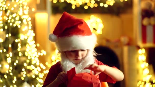 Felice anno nuovo. Il piccolo Babbo Natale con la barba e i baffi. Babbo Natale sceglie i biscotti. Babbo Natale. Babbo Natale prende un biscotto la vigilia di Natale come regalo di ringraziamento per aver lasciato i regali . — Video Stock