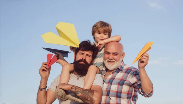 Cute child hugging his father and grandfather. — ストック写真