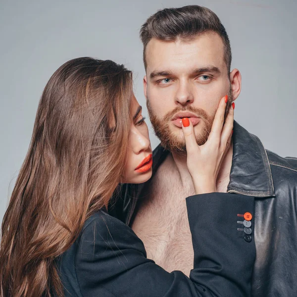 Passionate hug. Couple passionate people in love. Man brutal well groomed macho and attractive girl cuddling. Girlfriend passionate red lips and man leather jacket. She adores male brutal beard — ストック写真