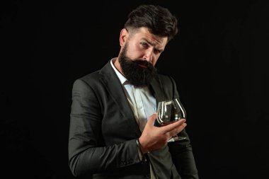 Yakışıklı sakallı iş adamı pahalı bir viski içiyor. Şarap garsonu. Sakallı adam elinde brendi bardağı tutuyor..