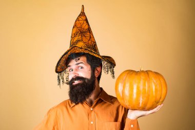 Balkabağıyla gülümseyen mutlu adam. Cadılar Bayramı Adamı balkabağıyla poz veriyor. Şükran Günü 'nü kutluyoruz. Mutlu Cadılar Bayramı.