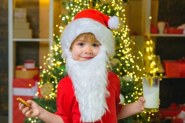 Śmieszne Boże Narodzenie. Święty Mikołaj. Mleko i ciasteczka dla Świętego Mikołaja. Święta dla dziecka. Portret brodatego zabawnego dziecka w stroju Mikołaja. Boże Narodzenie broda styl. — Zdjęcie stockowe