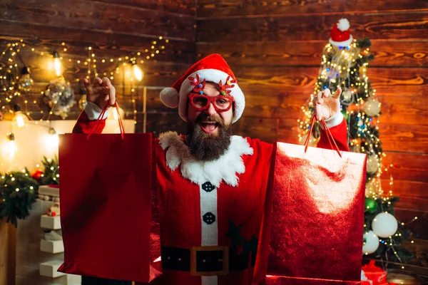 Noel hazırlığı. Yeni yılı kutlayan adam. Noel Baba hipster 'ı biçimlendirmek, uzun sakallı, Noel ağacından arka planda poz veren. Çılgın, komik hippi Noel Baba. — Stok fotoğraf