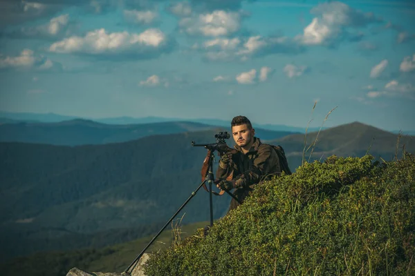 Calibres de rifles de caza. Curso de Educación Hunter. Rastrea. Un hombre armado. Hombre cazador guapo sosteniendo arma y caminando en el bosque . — Foto de Stock