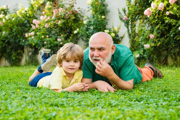 Happy family Grandson hugs his grandpa on holiday. Family summer and active holidays. Grandfather with son in park. Grandson embrace his grandfather. — Stock Photo, Image