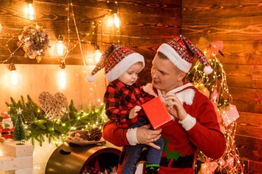 Kış tatili konsepti. Oğluna tapıyor. Sihirli atmosfer aile tatili. Babalık sevinci. Oğluyla geçirdiği her anın tadını çıkar. Tatilleri birlikte geçirin. Baba ve oğul Noel 'i evde kutluyorlar.