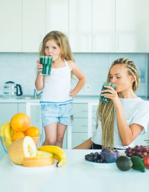 Çocuklar için yiyecek ve içecek. Anne ve kızı meyvelerle kokteyli karıştırıyor. Vejetaryen konsepti. Sağlıklı yaz içkisi. Doğal antioksidan..