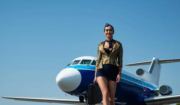 Stewardess and travel time. Portrait of smiling flight attendant serving on airplane background. Flight attendant uniform. Plane travel. Woman stewardess. Copy spase, isolated on blue.