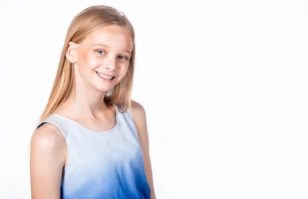 Retrato de una niña creativa inteligente con el pelo rubio, sonriendo ampliamente, esperando a que un amigo juegue juntos en la escuela, sintiéndose confiado y despreocupado sobre la pared gris. Copiar espacio . —  Fotos de Stock