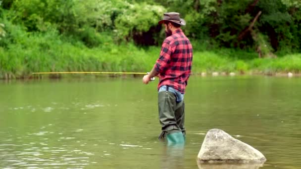 Visser met vishengel op de rivier. Bruine forel vis. Zomervakantie en mensen concept. Forel aan een haak. Hij houdt bruine forel vast. Vliegvissen op forel. — Stockvideo