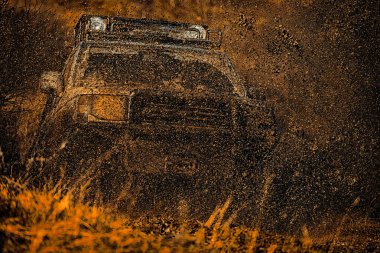 Jeep açık hava maceraları. Çamur, ıslak çamur veya kilden oluşan bir alandan geçmektir. Tekerlekleri ve kumdaki toza dönen off-road 'u hareket ettir..