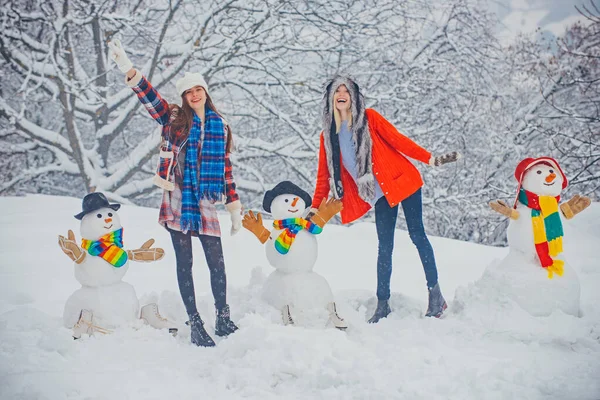 Karácsonyi téli emberek. Lányok játszanak Hóemberrel - elszigetelve a hóban. Vicces téli emberek Portré. — Stock Fotó