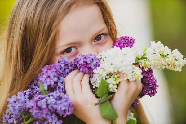Zweet knap Europees klein meisje met lila. Sluit de ogen van kinderen. Geniet van de lente zonder allergie. Voorjaarsbloei. Pollenallergie. Allergie bloeiseizoen. — Stockfoto