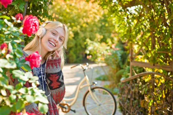 Girl ride bicycle for fun. Blonde enjoy relax in park or garden. Active girl with bicycle. Motion and energy. Woman with bicycle in blooming garden. Weekend activity. Active leisure and lifestyle