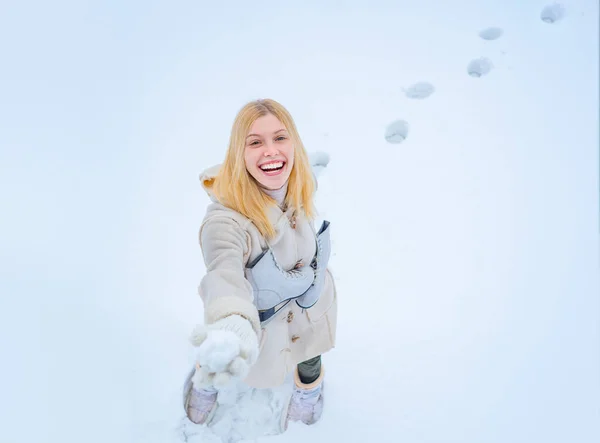 Utomhus foto av unga vackra glada leende flicka promenader på vit snö bakgrund. Vacker kvinna njuter av första snön. — Stockfoto