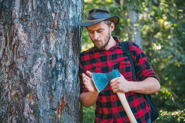 Trabajador de leñadores caminando por el bosque con hacha. La deforestación es una de las principales causas de degradación de la tierra y desestabilización de los ecosistemas naturales . —  Fotos de Stock