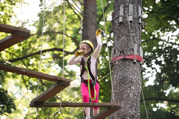 Early childhood development. Teenager girl adventure and travel. Toddler climbing in a rope playground structure. Toddler kindergarten. Balance beam and rope bridges. — Stock Photo, Image