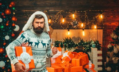 Ahşap arka planda poz veren uzun sakallı bir stilist. Yeni yıl partisi. Yeni yıl moda kıyafetleri.