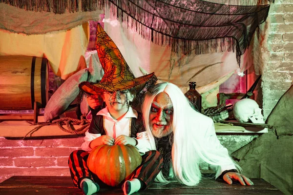 Uma noite terrível no Halloween. Pai e filho se divertem no Halloween. A família feliz celebra o Halloween. Homens e rapazes assustam os convidados. Histórias assustadoras . — Fotografia de Stock