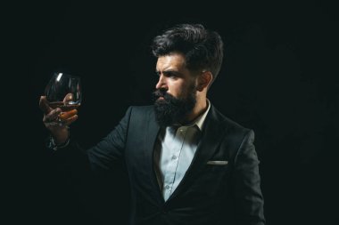 Viski, konyak ya da konyak içmek. Klasik klasiklerde zarif ve şık bir adam elinde bilge bir bardakla gezer. Bir bardak viski tutan şık zengin adam..