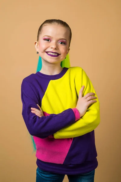 Adorable niña en ropa casual posando en la cámara. Retrato de estudio de colegiala con pelo colorido sobre fondo aislado . — Foto de Stock