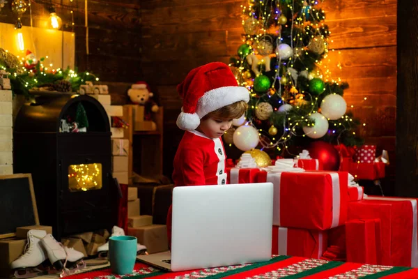 Férias e conceito de infância de inverno. Criança de Natal sonha. Bebê adorável desfrutar de Natal. Feliz Ano Novo. Menino decorando árvore de xmas e abrindo presentes. — Fotografia de Stock