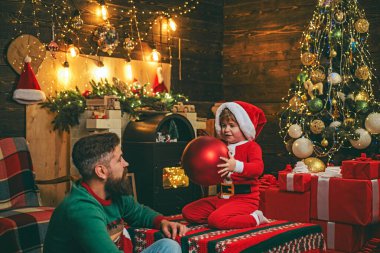 Mutlu Noeller ve mutlu tatiller. Noel ailesi. Noel hediyesi kutusu olan mutlu bir baba ve oğul. Ev Noel atmosferi.