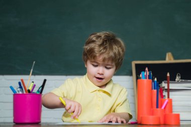 Öğretmenler günü - okulda öğrenci eğitimi. Çocuk okulu. Çocuk sınıfta tahtada öğreniyor..