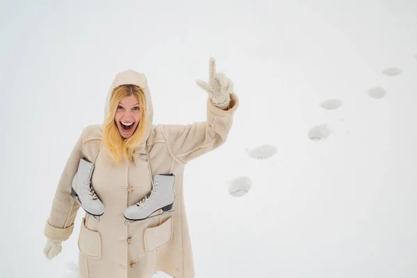 Seriemördare. Vacker blond hår flicka jag vinter kläder utomhus. Julen. Vacker flicka på vintern utomhus. Vacker leende ung kvinna i varma kläder med skridskor. — Stockfoto