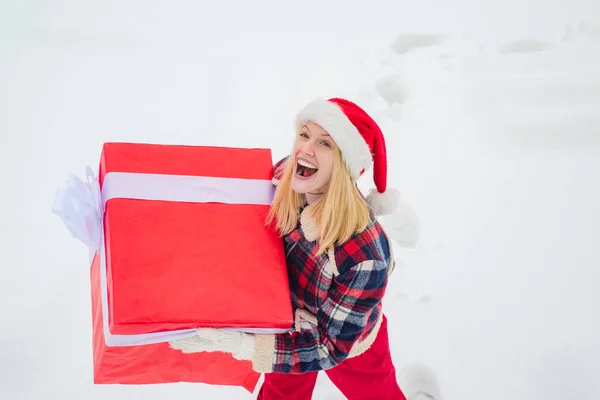 Promotion et bonus. Joyeux Noël et Joyeuses Fêtes. Noël hiver gens. Fais un cadeau. Portrait de Santa femme avec un énorme cadeau rouge regardant la caméra . — Photo